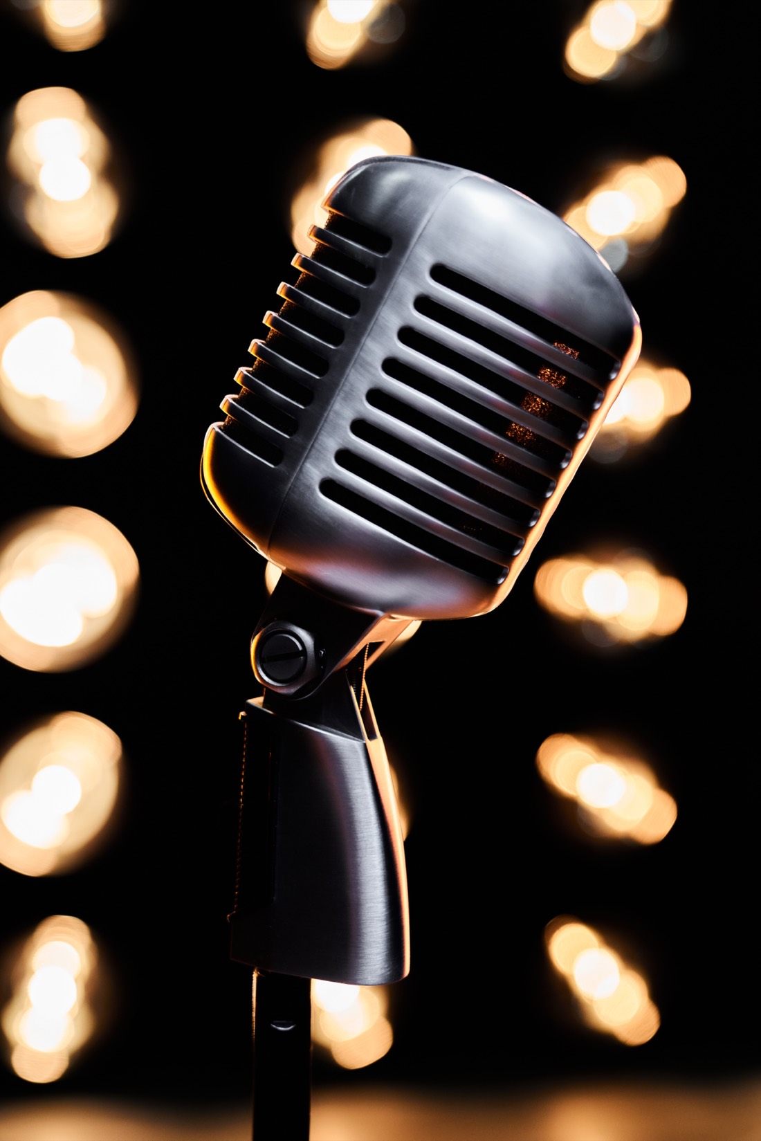 A vintage microphone lit by warm stage lights